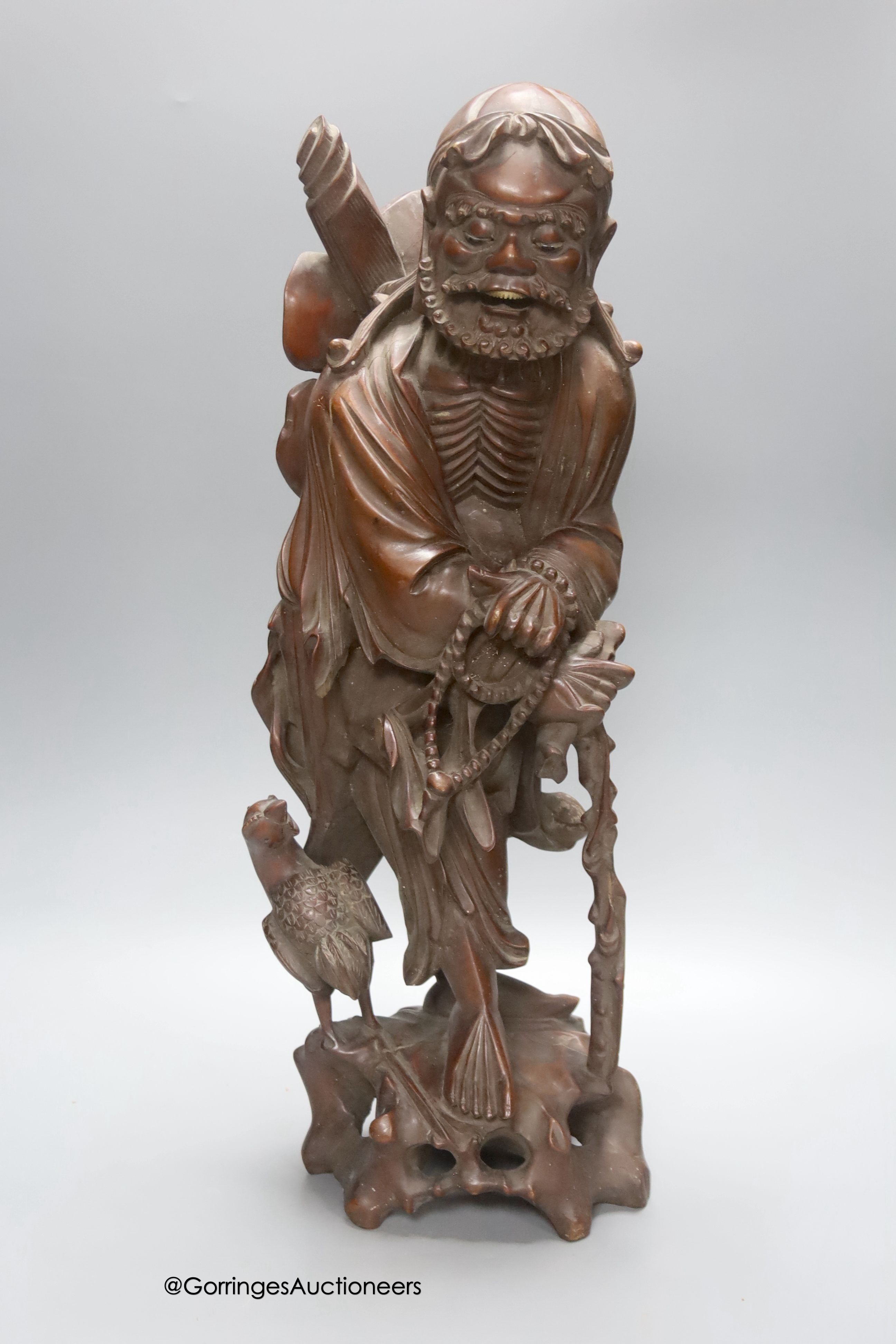 An early 20th century Chinese hardwood carving of a luohan figure, height 52cm